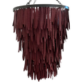 A modern tiered chandelier featuring dark reddish-brown hanging seed pod shaped clay elements 